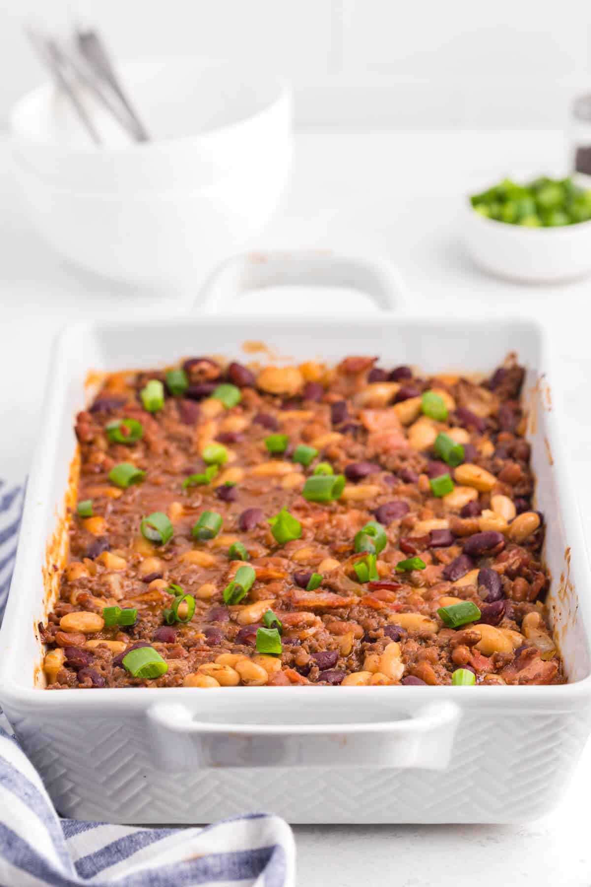 Baked bean casserole in a white casserole pan.