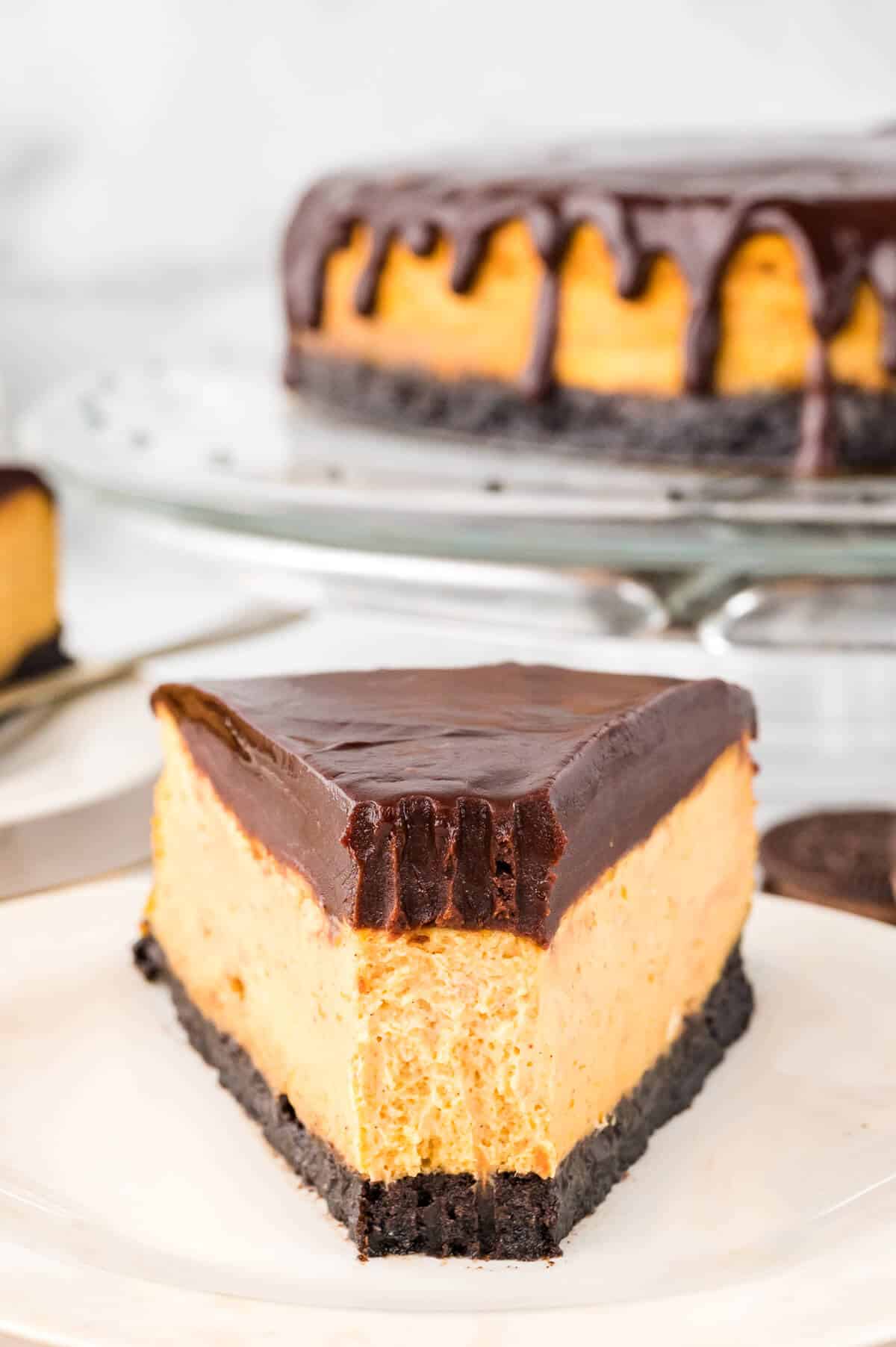 Chocolate Pumpkin Cheesecake slice on a plate with a bite off the end.