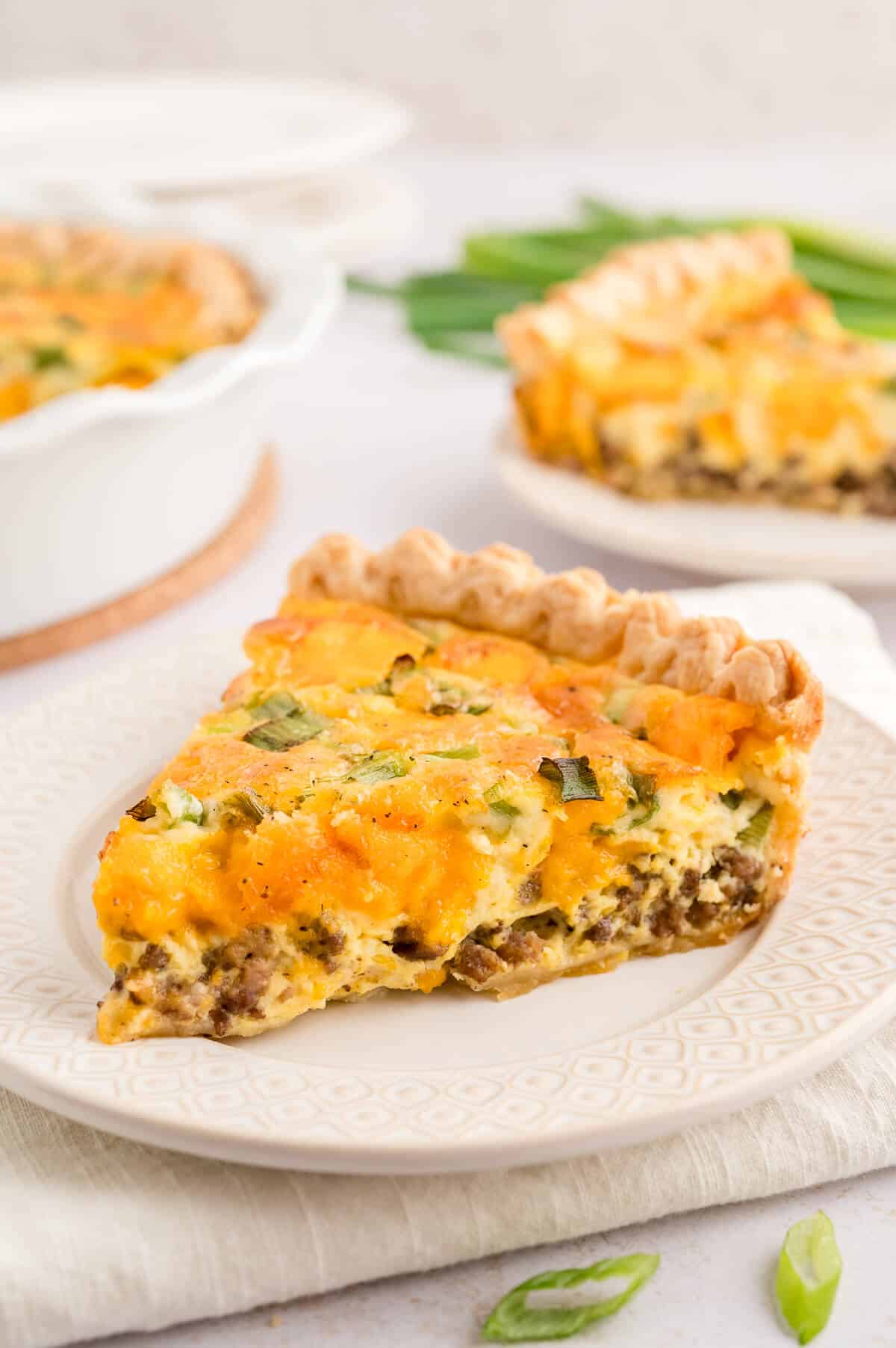 A slice of hamburger quiche on a plate.