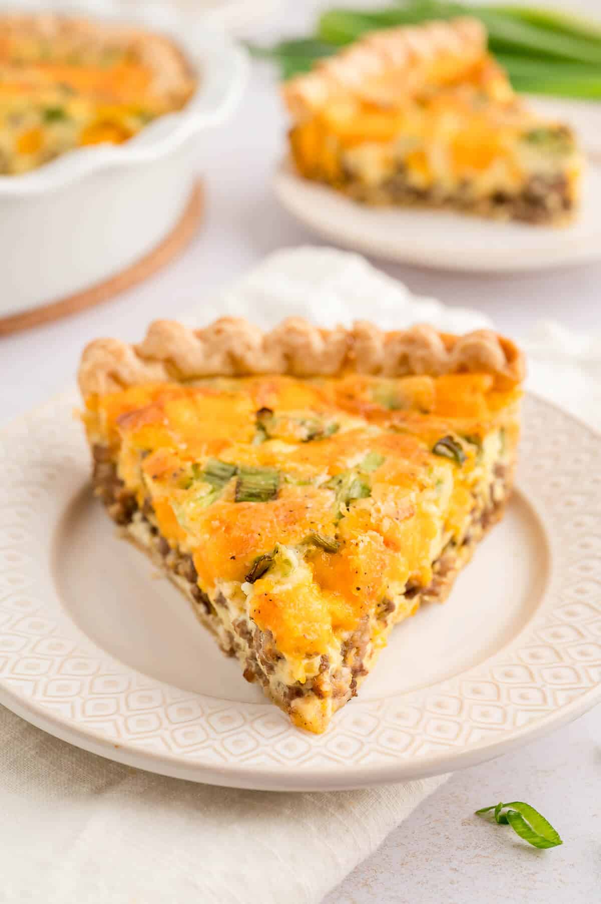 A slice of hamburger quiche on a plate.