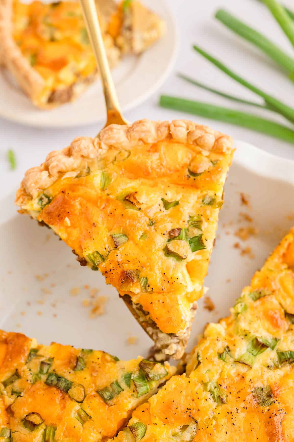 Hamburger quiche slice on a spatula.