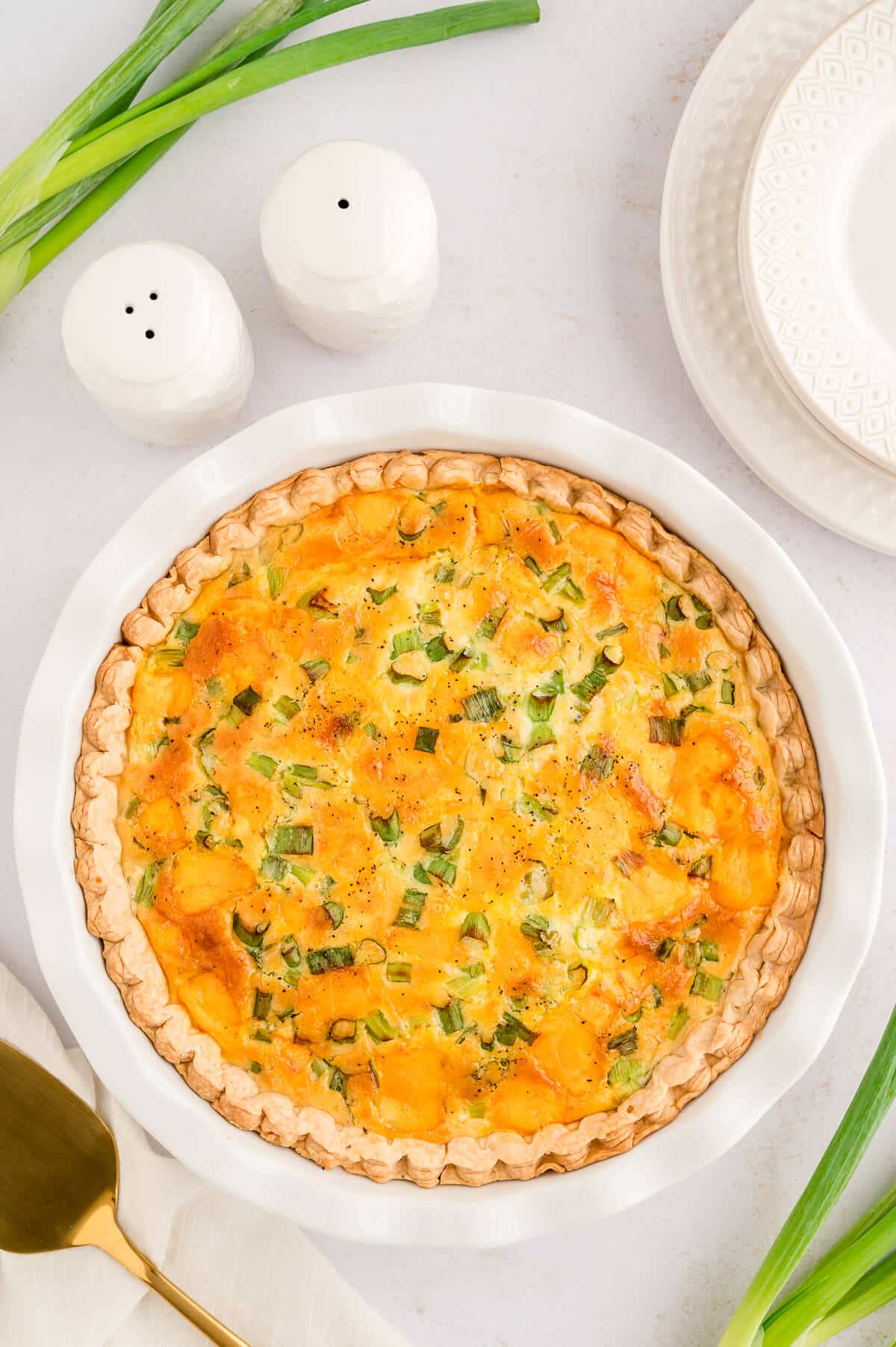 Hamburger quiche in a white pie pan.