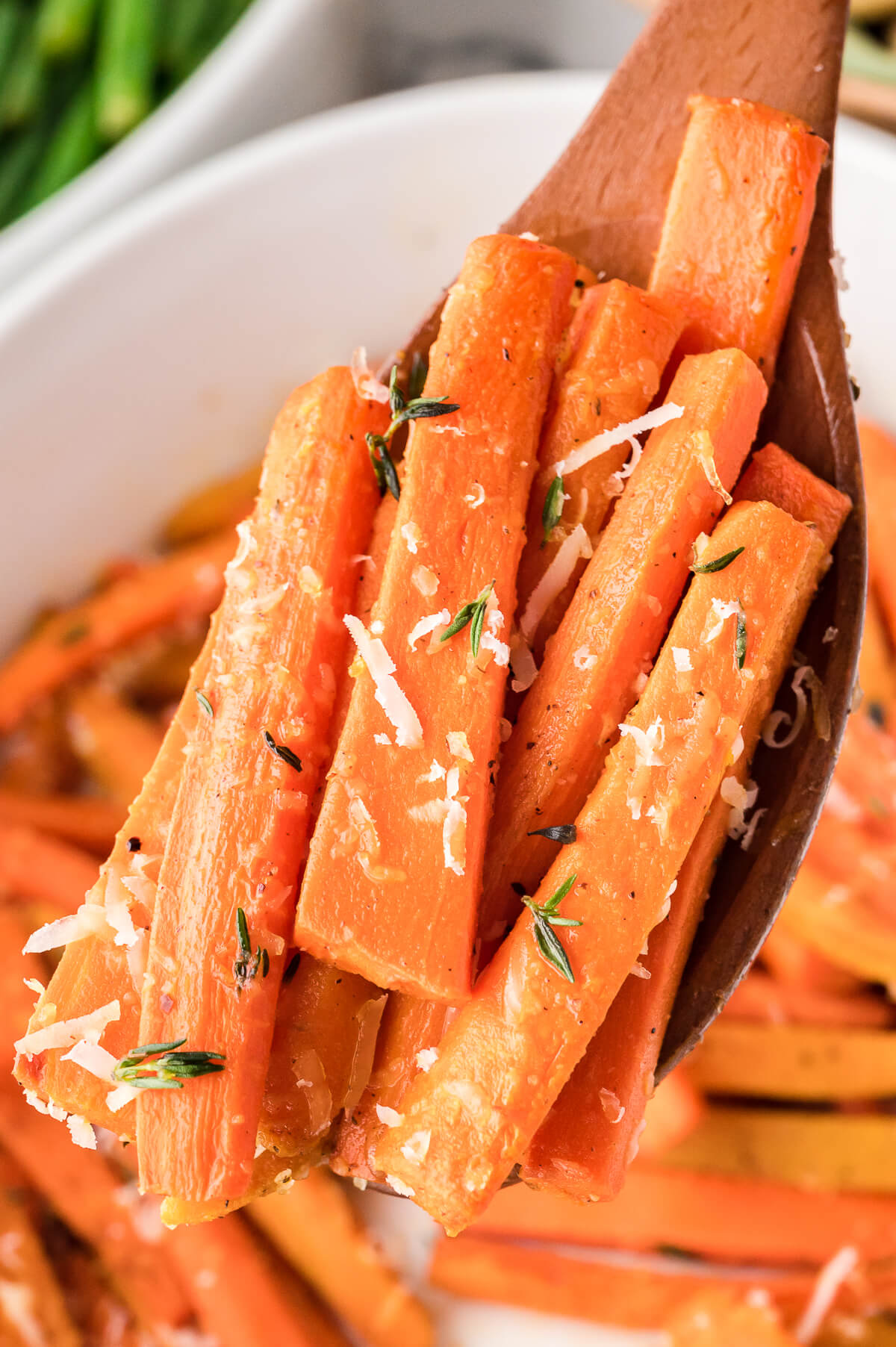 Parmesan roasted carrots on a wooden serving spoon.