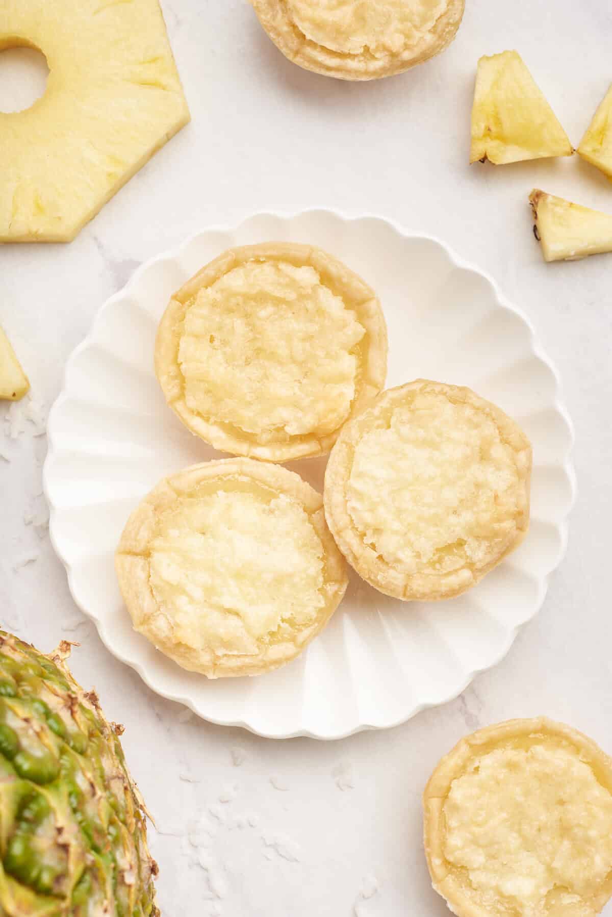 Three pineapple tarts on a plate.