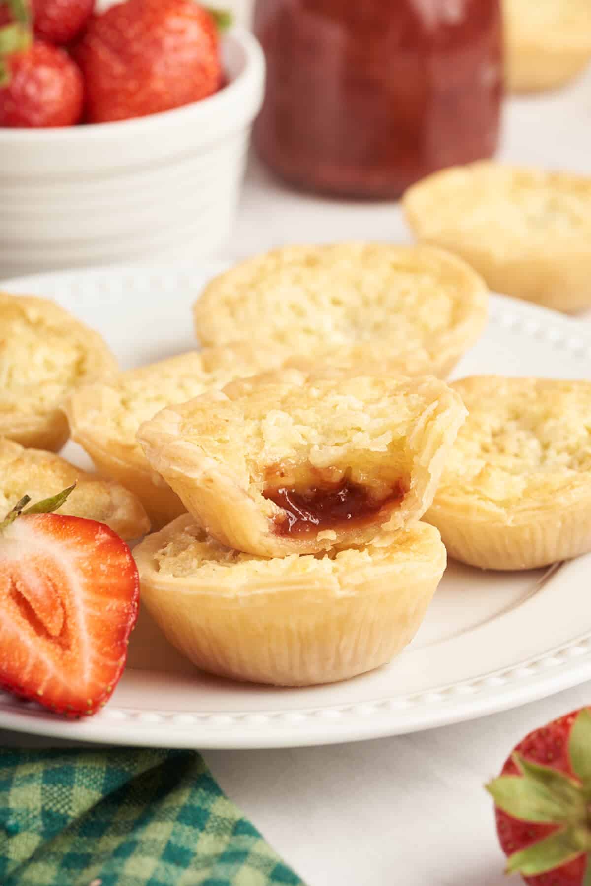 Strawberry coconut tarts on a plate.