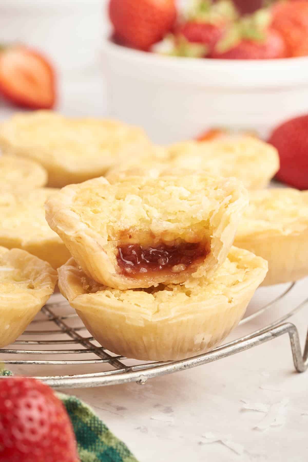 Strawberry coconut tarts on a rack.