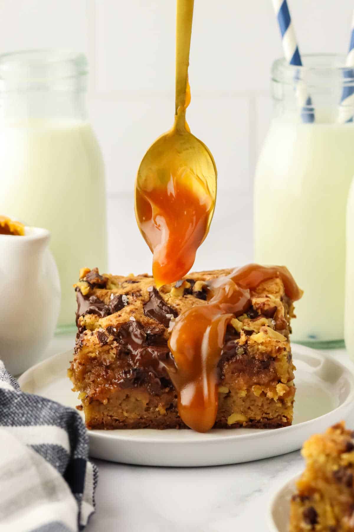 A spoon drizzling caramel over a piece of the recipe.