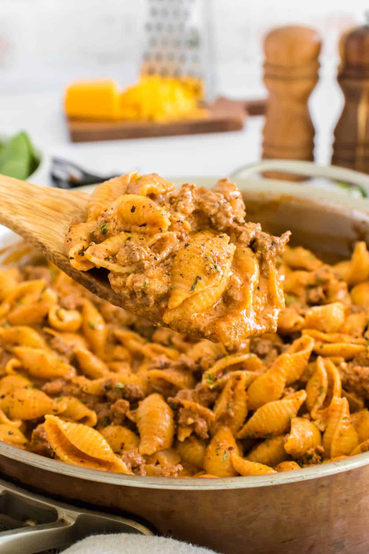 Creamy beef and shells on a serving spoon.