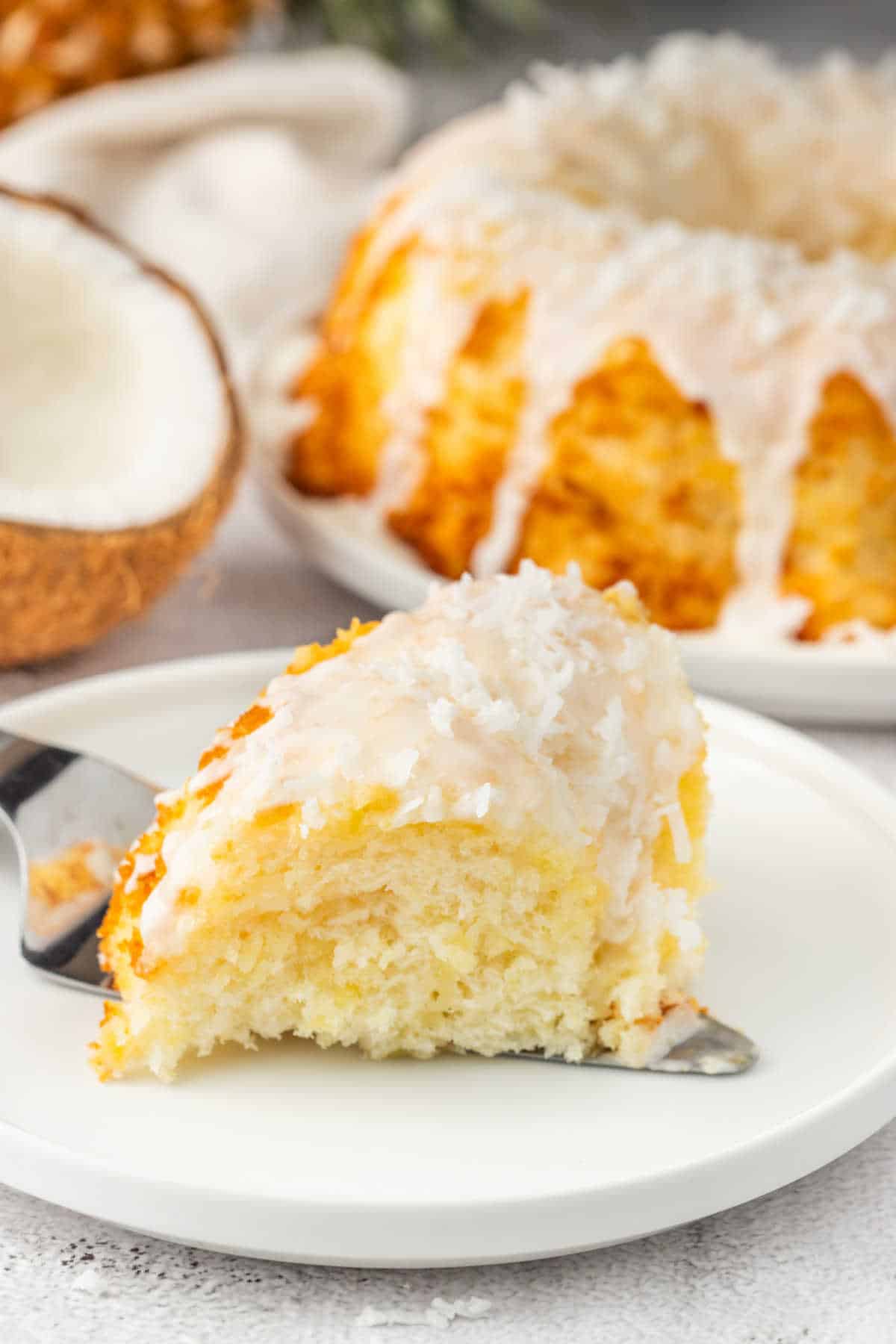 A piece of pineapple coconut bundt cake on a plate.