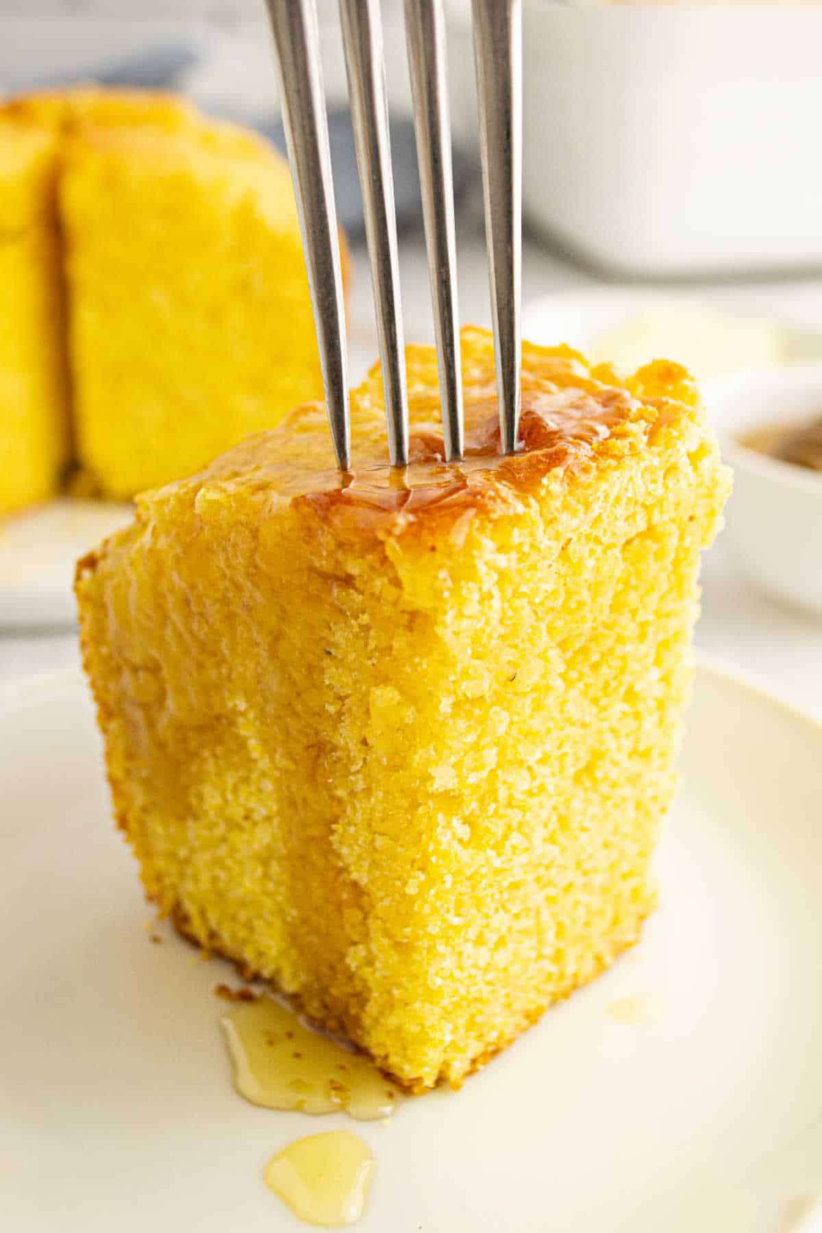 A piece of southern corn cake with a fork in it.