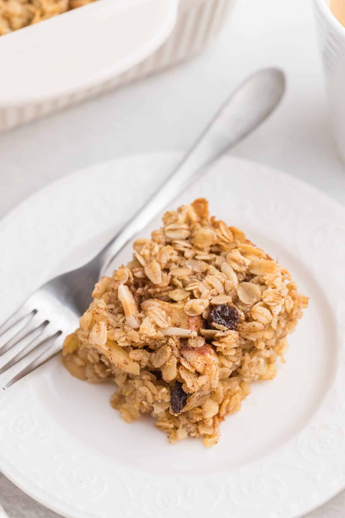 A slice of baked oatmeal on a plate with a fork.