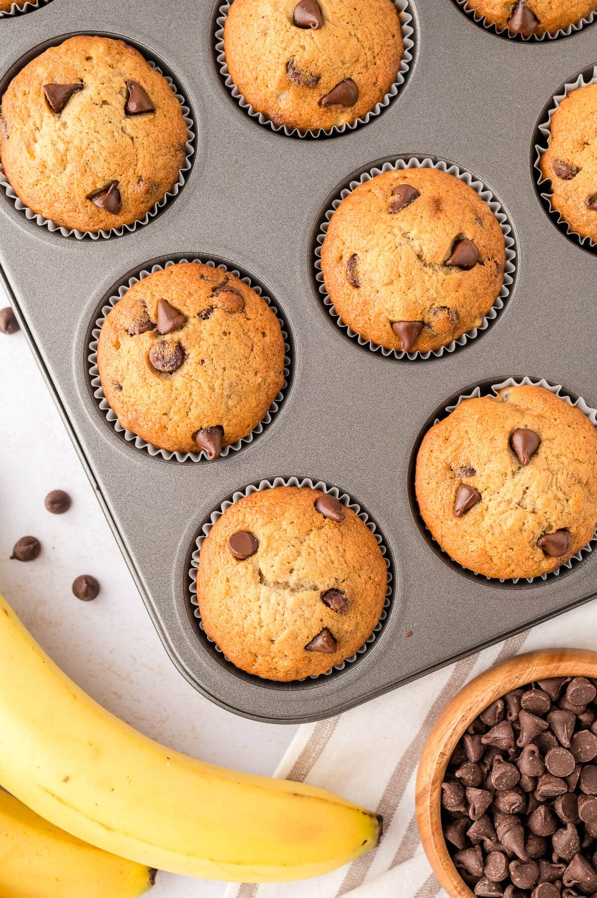 Banana chocolate chip muffins in a muffin pan. 