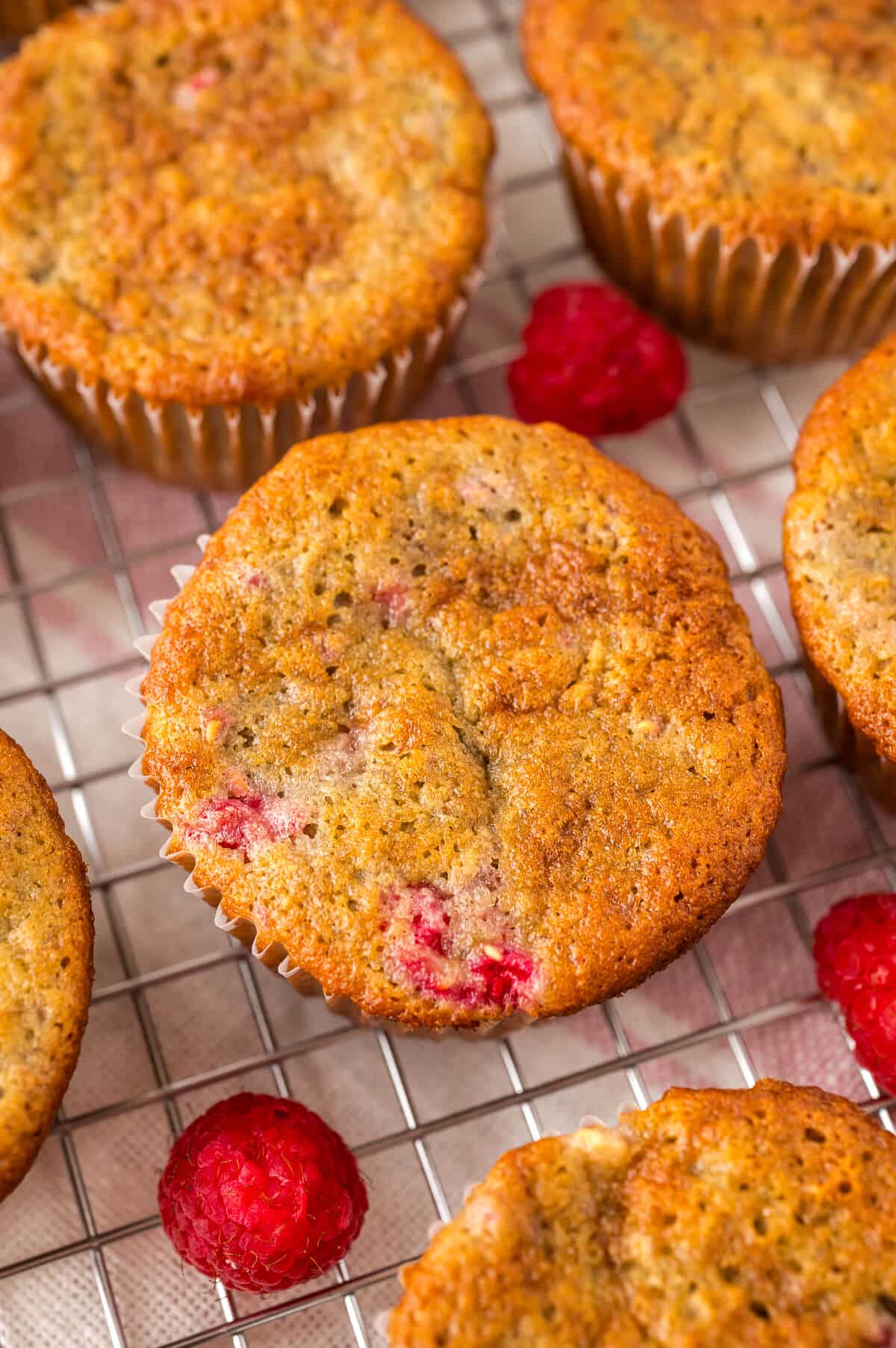 Banana raspberry muffins on a wire rack.