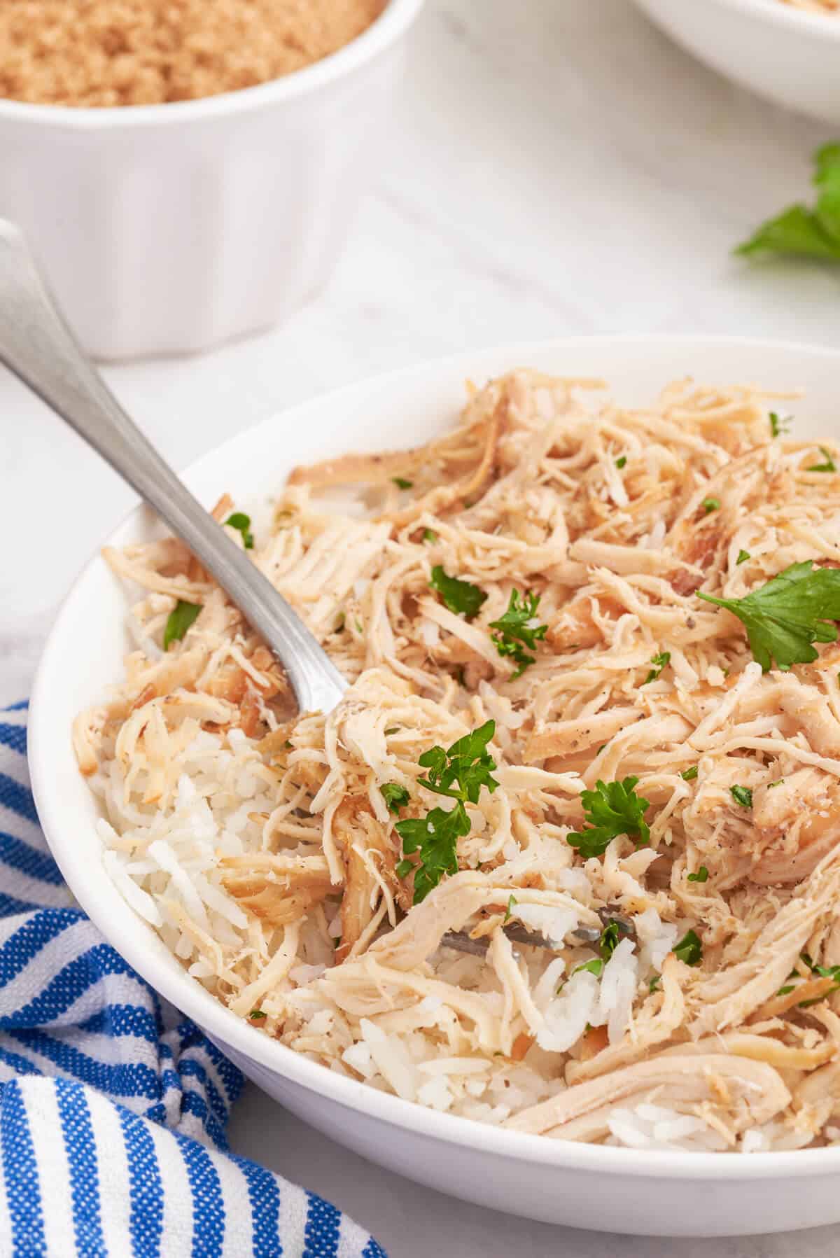 Brown sugar chicken in a bowl with a fork.