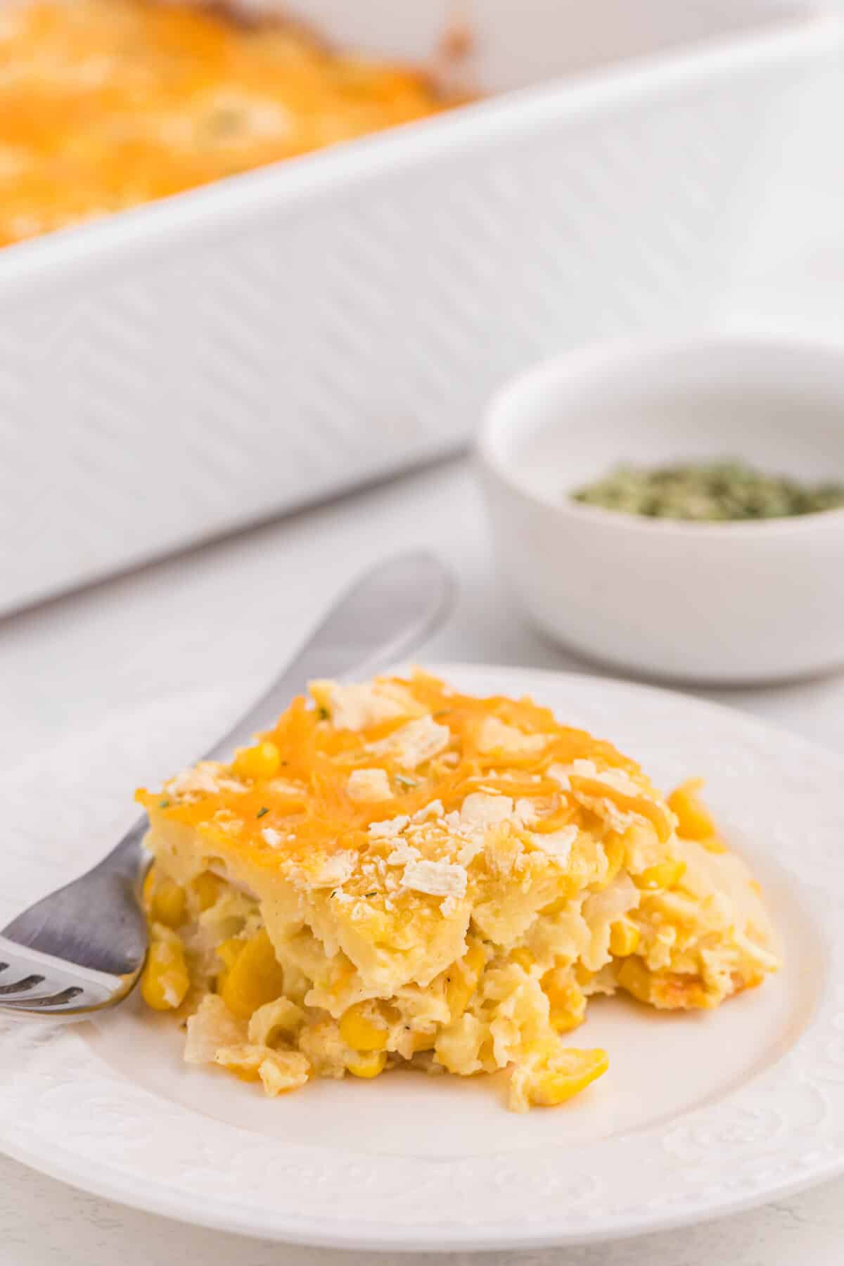 A piece of casserole on a plate with a fork.