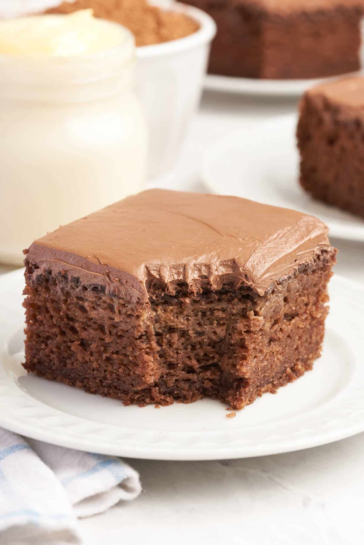 A piece of mayonnaise cake on a plate with a bite out of it.