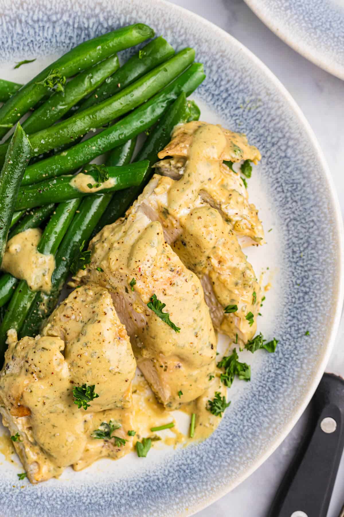 Mustard chicken and green beans on a plate.