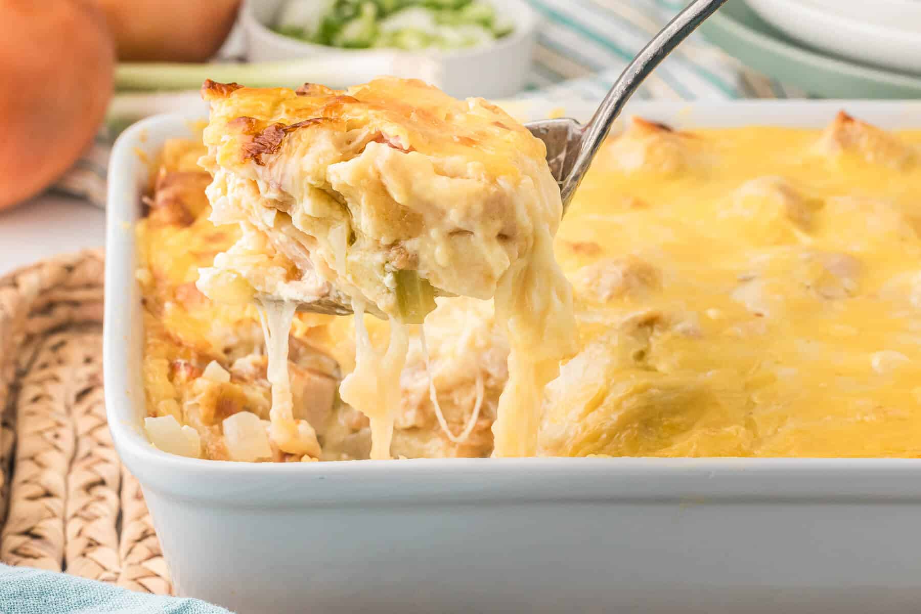 A serving spoon with chicken cordon bleu casserole on it.