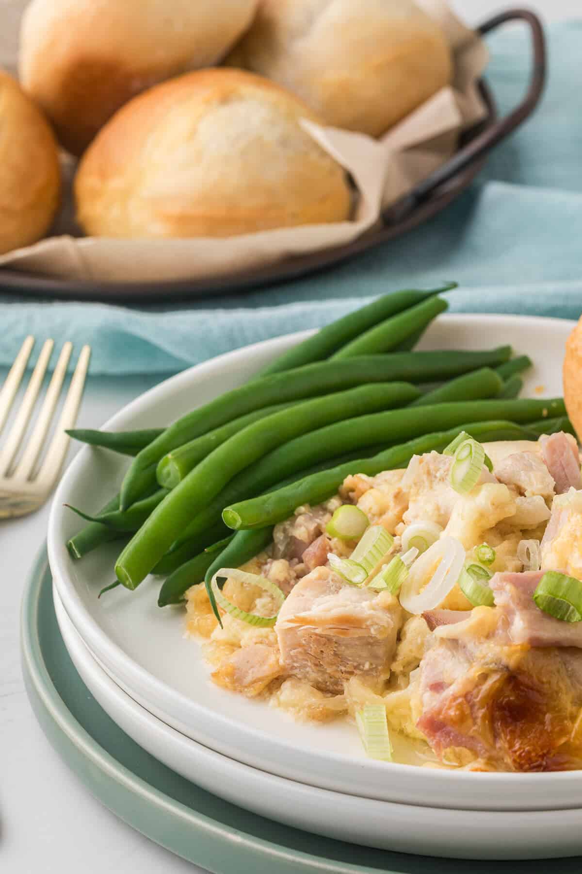 Chicken cordon bleu casserole on a plate with green beans.