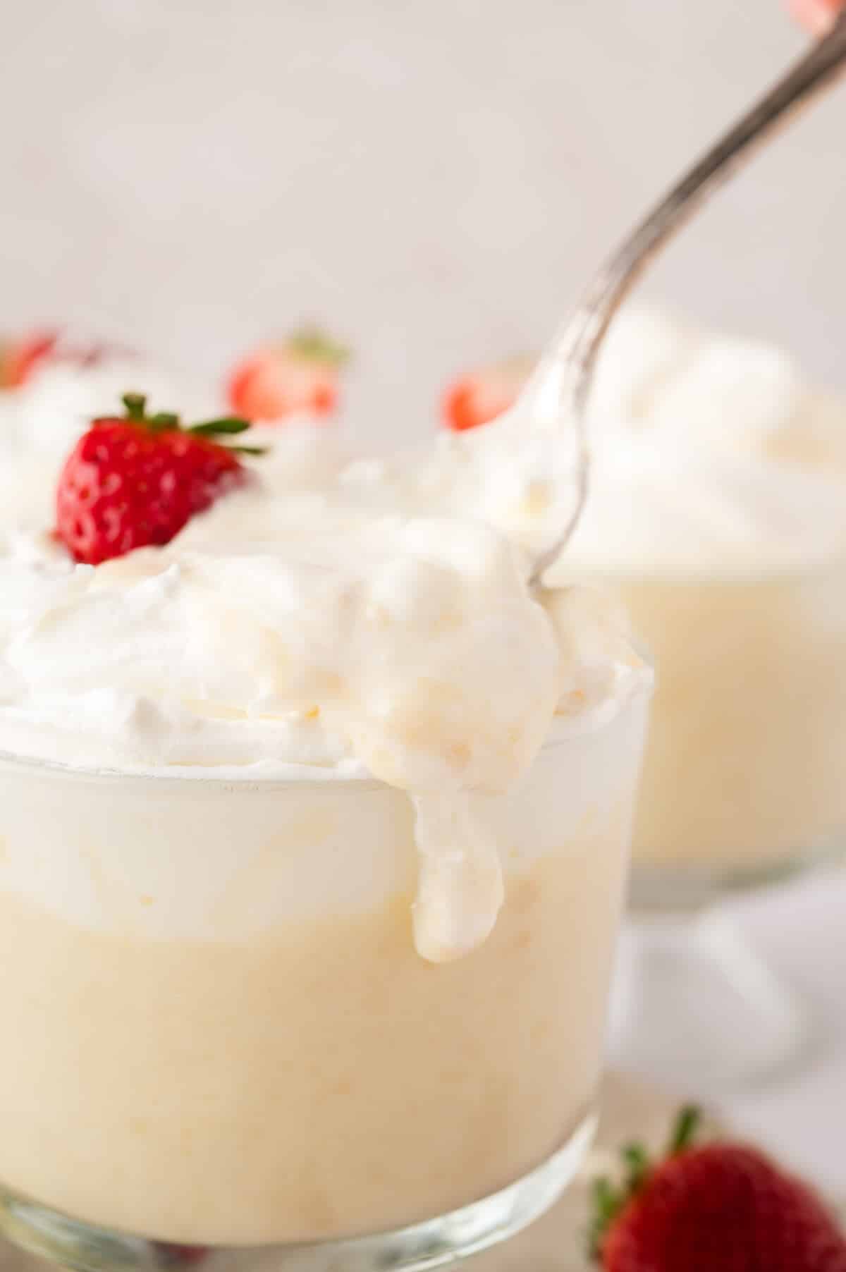 Cracker pudding in a parfait dish with a spoon.