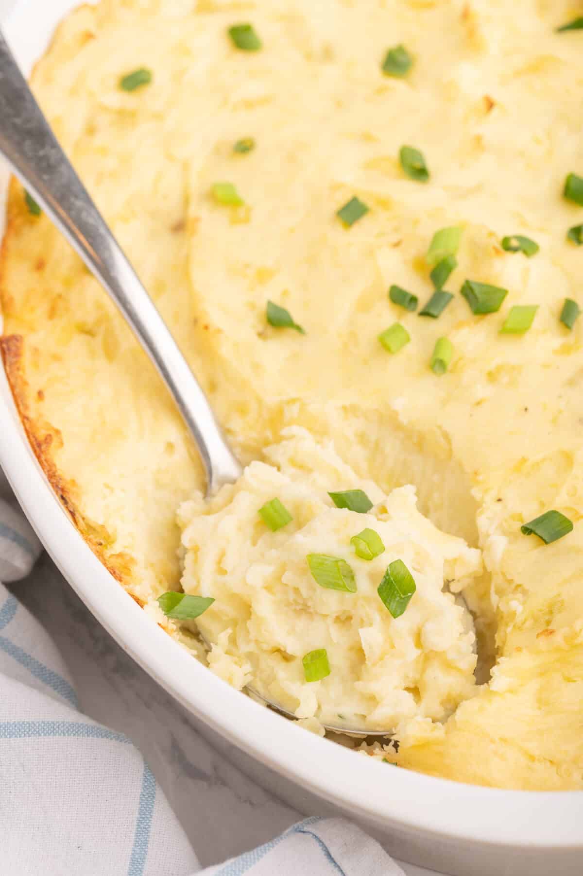 A serving spoon in a dish of the potatoes.