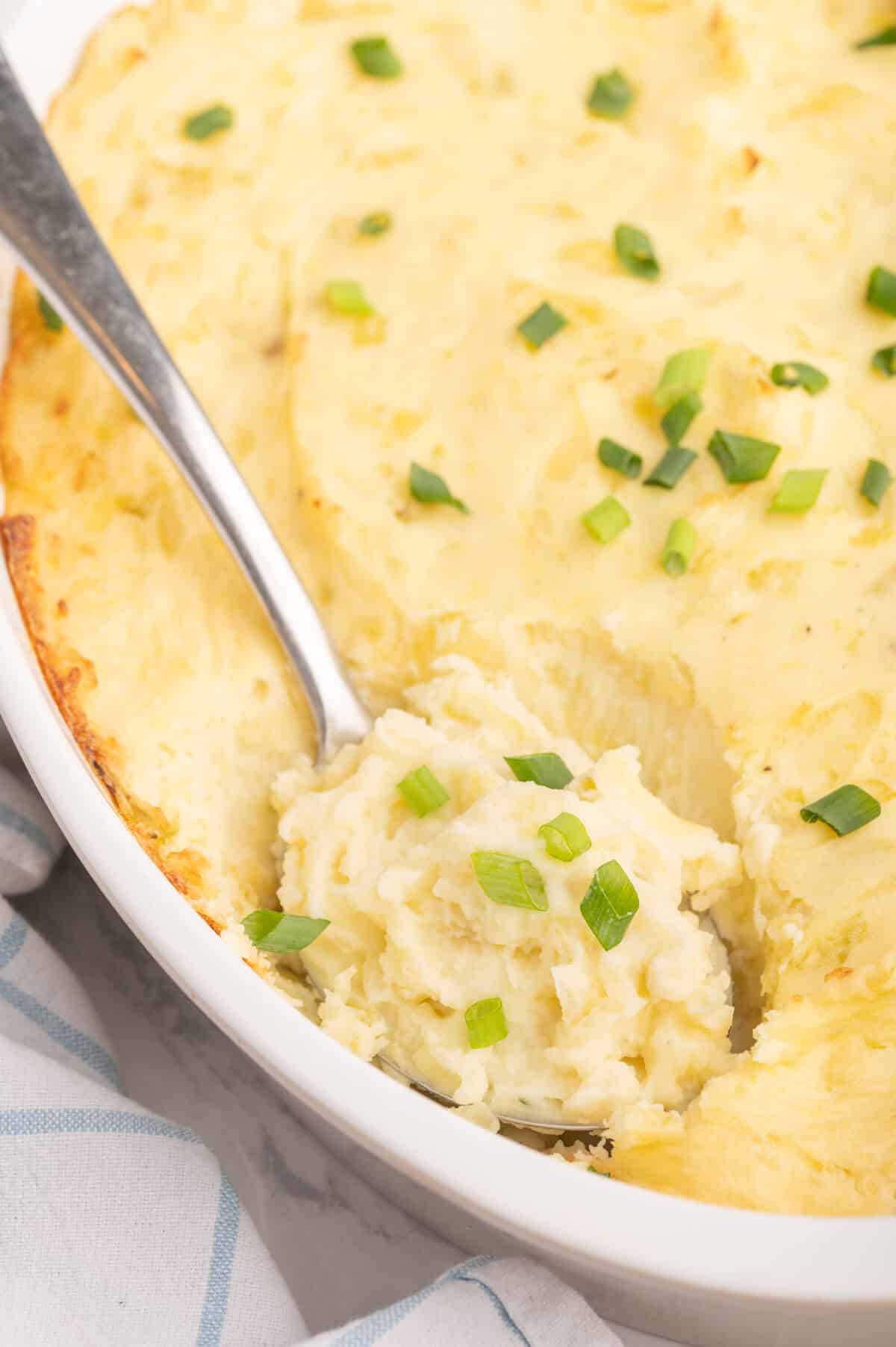 A serving spoon in a dish of Irish potatoes.