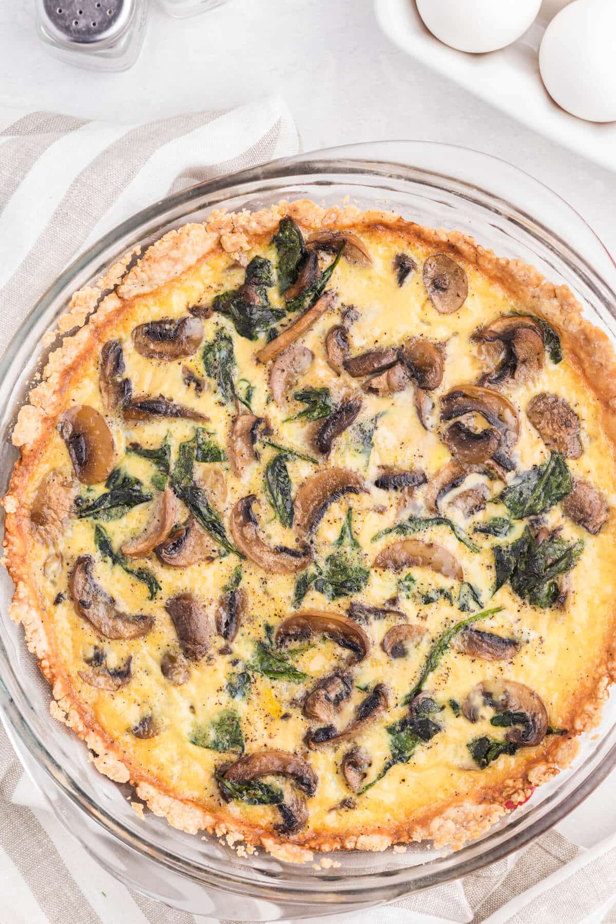 Spinach mushroom quiche in a pie pan.