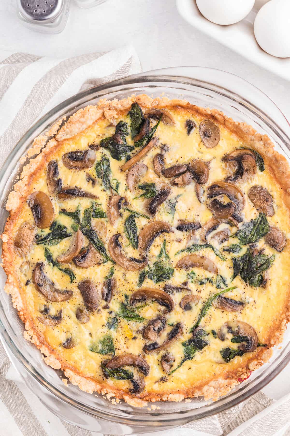 Spinach mushroom quiche in a pie pan.