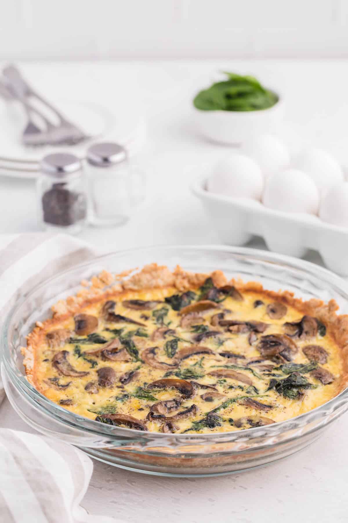 Spinach mushroom quiche in a pie pan.