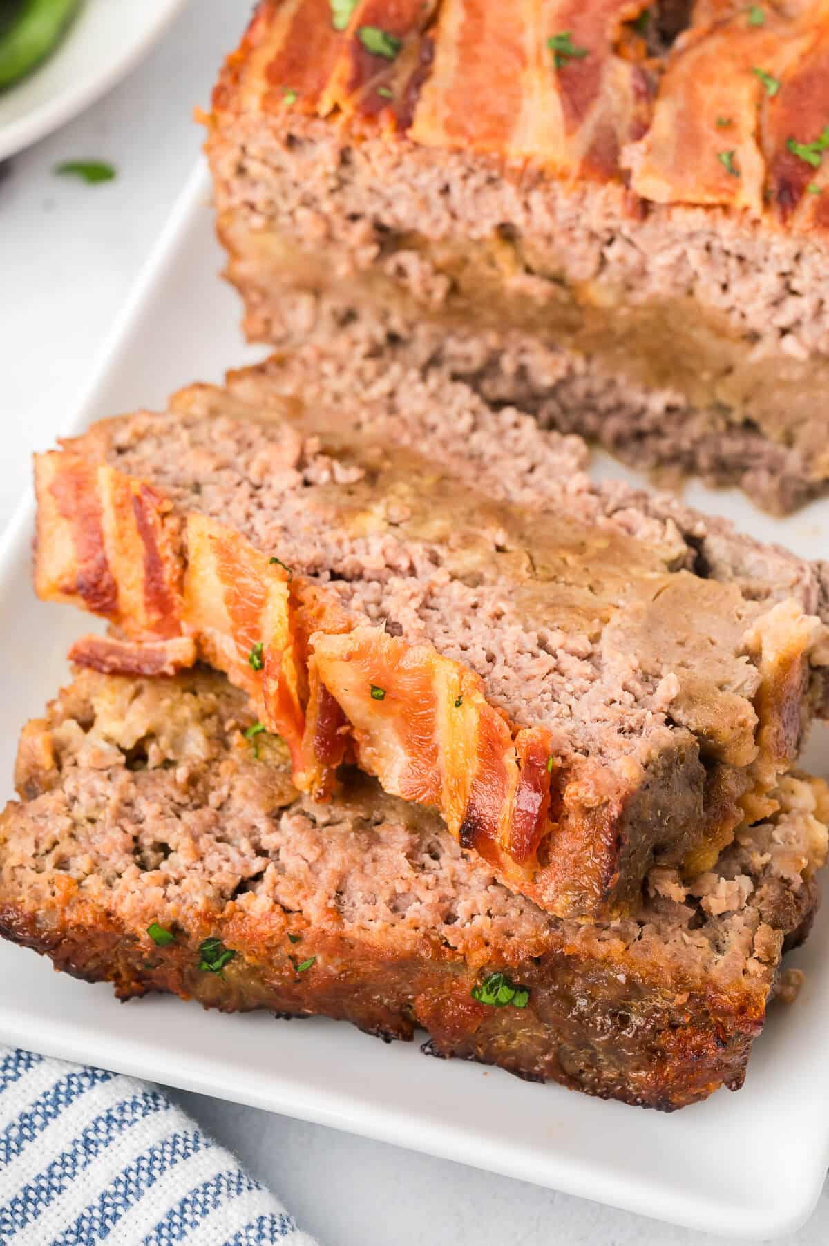 Sunday meatloaf on a platter with slices cut.