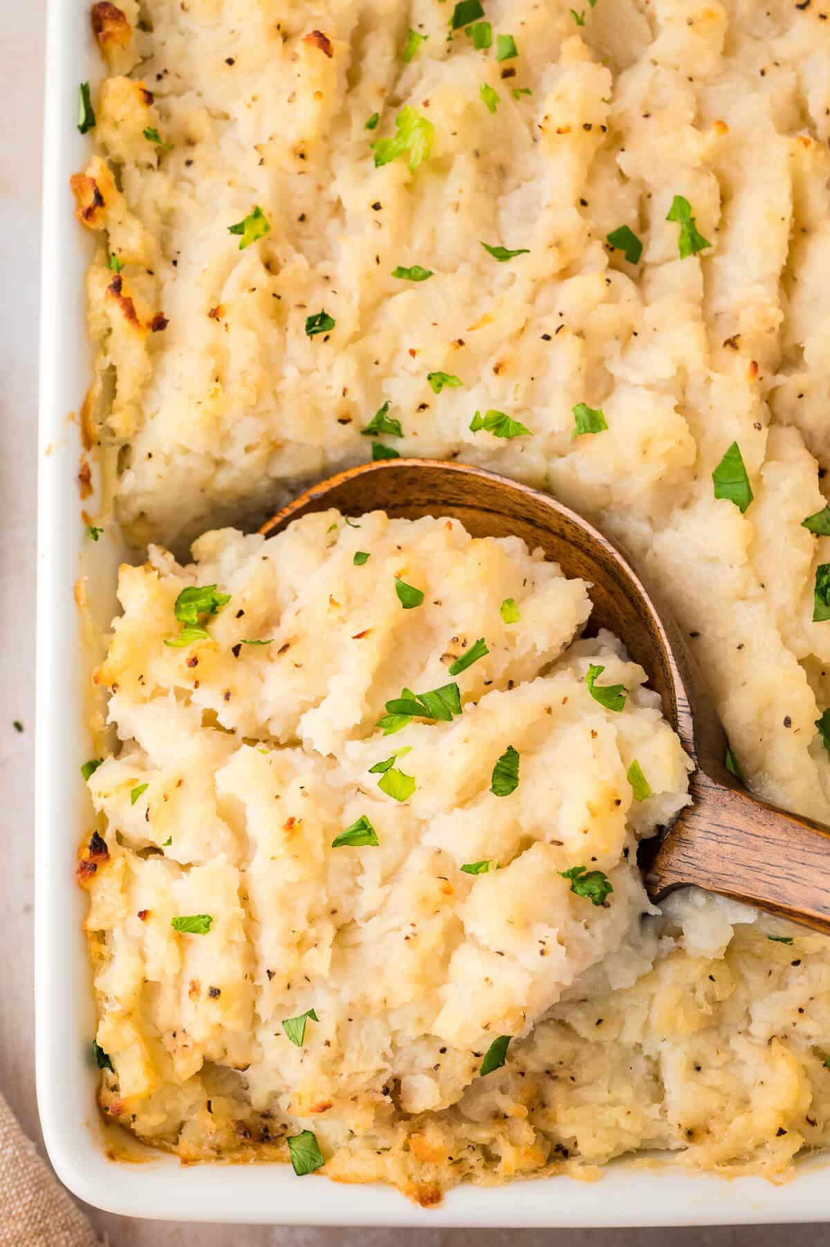 Turnip casserole in a pan with a wooden spoon.