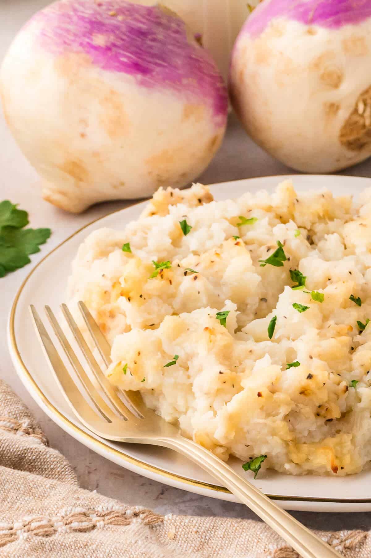 Turnip casserole on a plate with a fork.