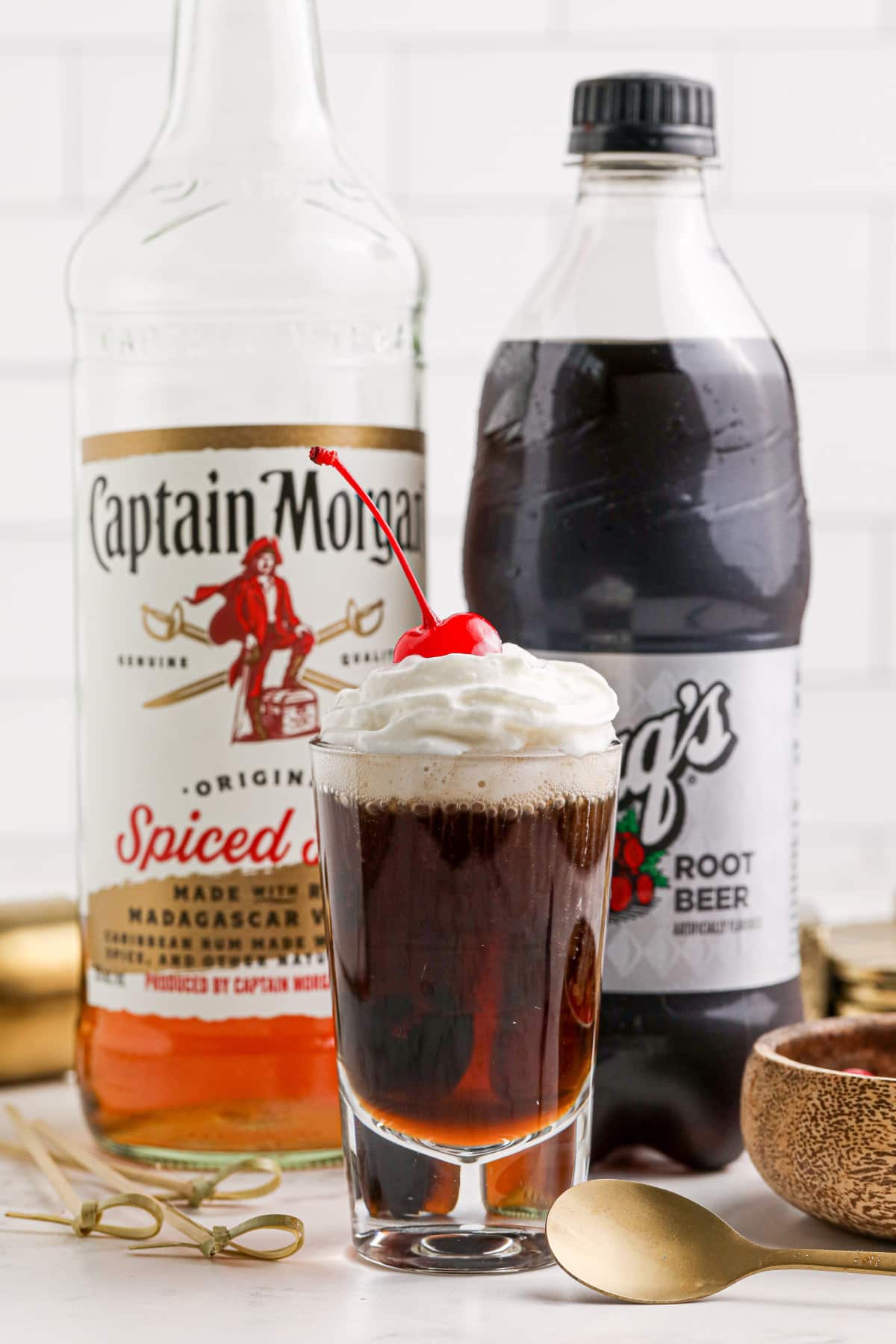 A root beer shooter with ingredients behind.