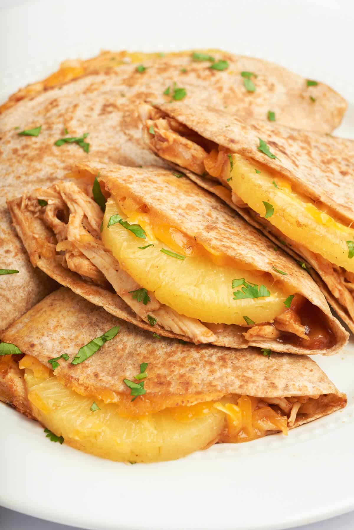 A plate of bbq chicken and pineapple quesadillas.