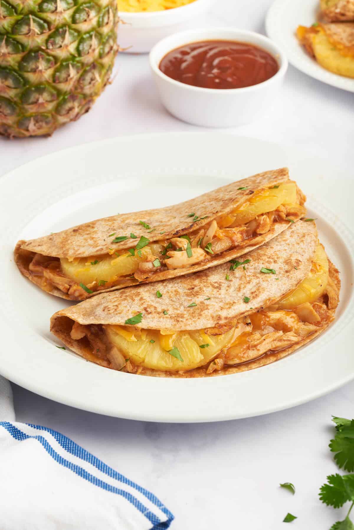 A plate of bbq chicken and pineapple quesadillas.