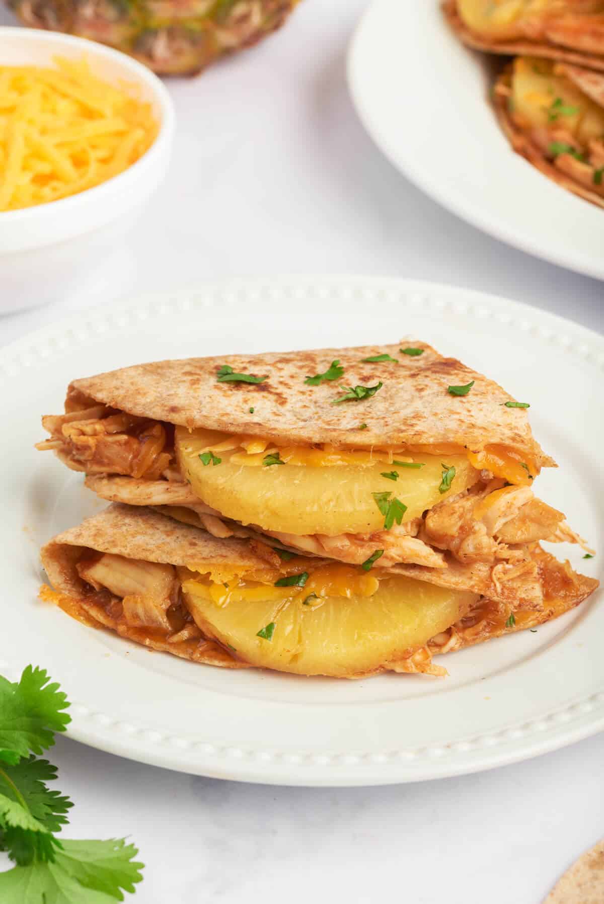A plate of bbq chicken and pineapple quesadillas.