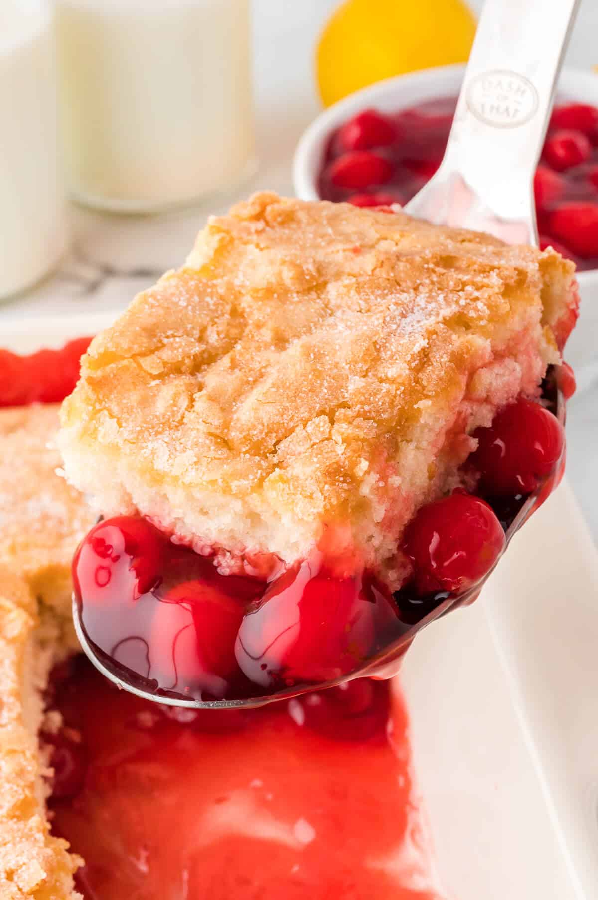 A piece of cherry pudding cake on a serving spoon.