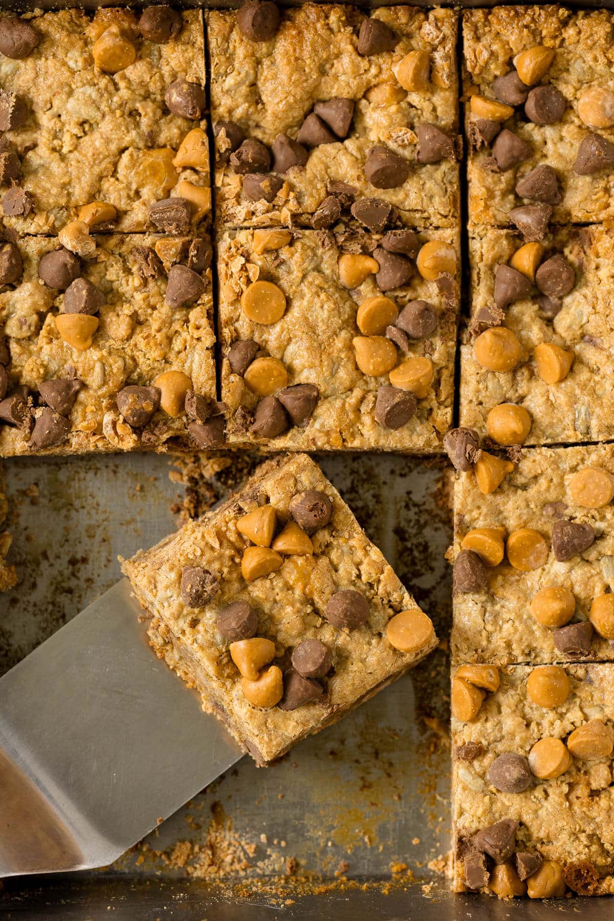 Chewy bars in the pan with a spatula.