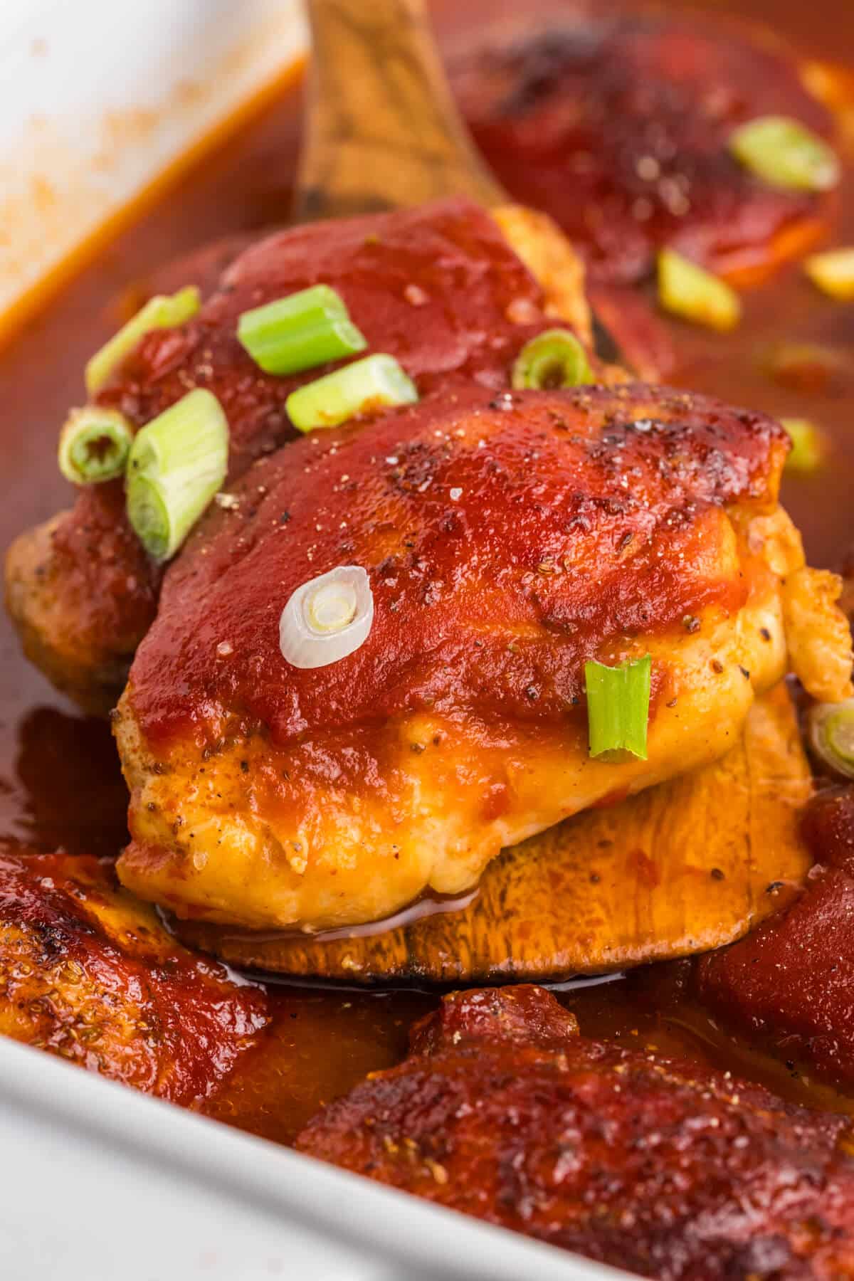 Sweet and sour chicken on a wooden serving spatula.