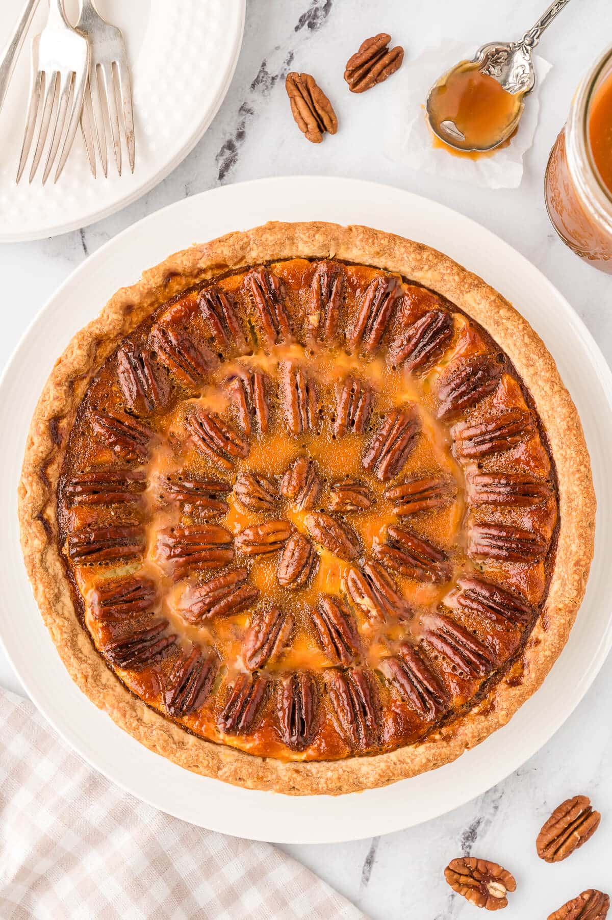 A pecan pie cheesecake on a white surface.