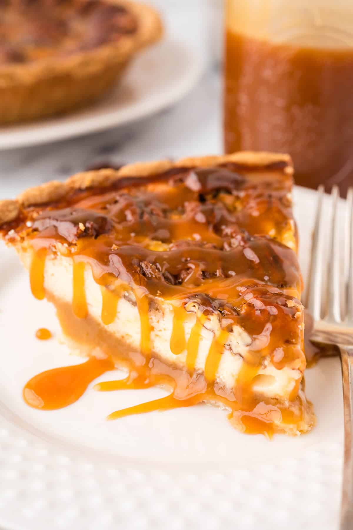 A slice of pecan pie cheesecake on a plate.