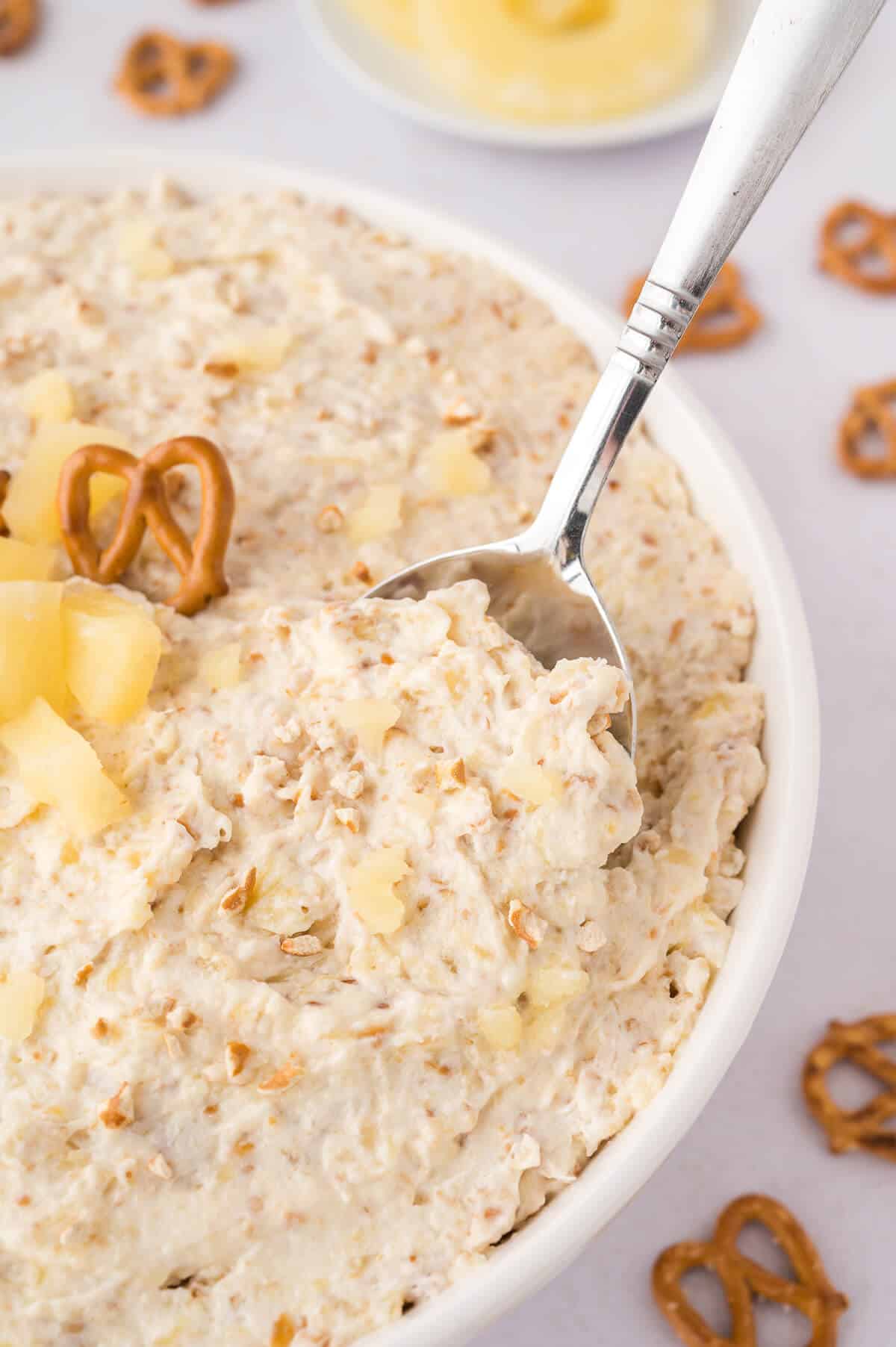 Pineapple pretzel fluff in a bowl with a spoon.