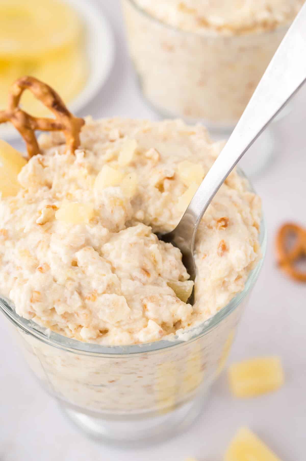 Pineapple Pretzel Fluff in a parfait dish with a spoon.