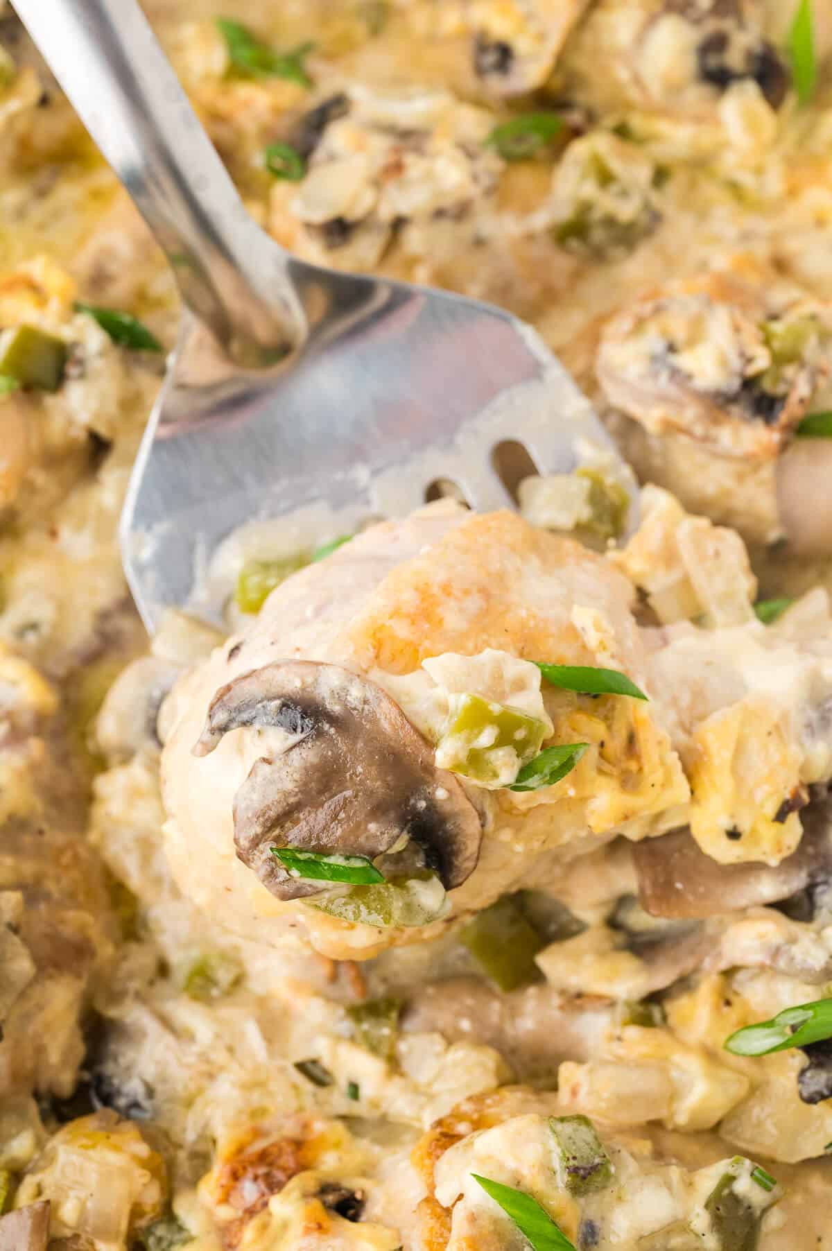 Smothered chicken on a serving spoon.