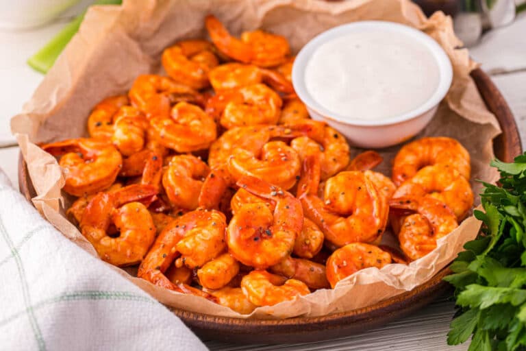 Buffalo shrimp in a bowl with ranch dipping sauce.