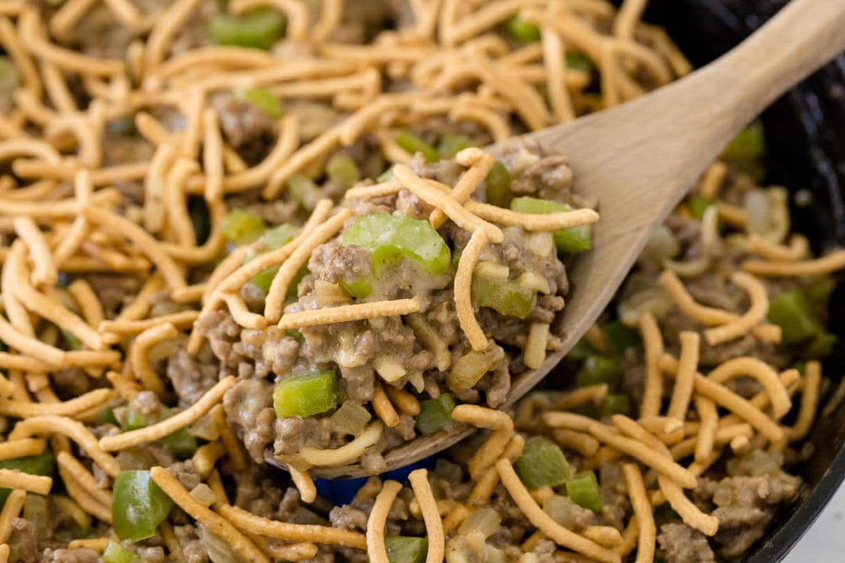 Chow mein skillet in a pan with a wooden spoon.