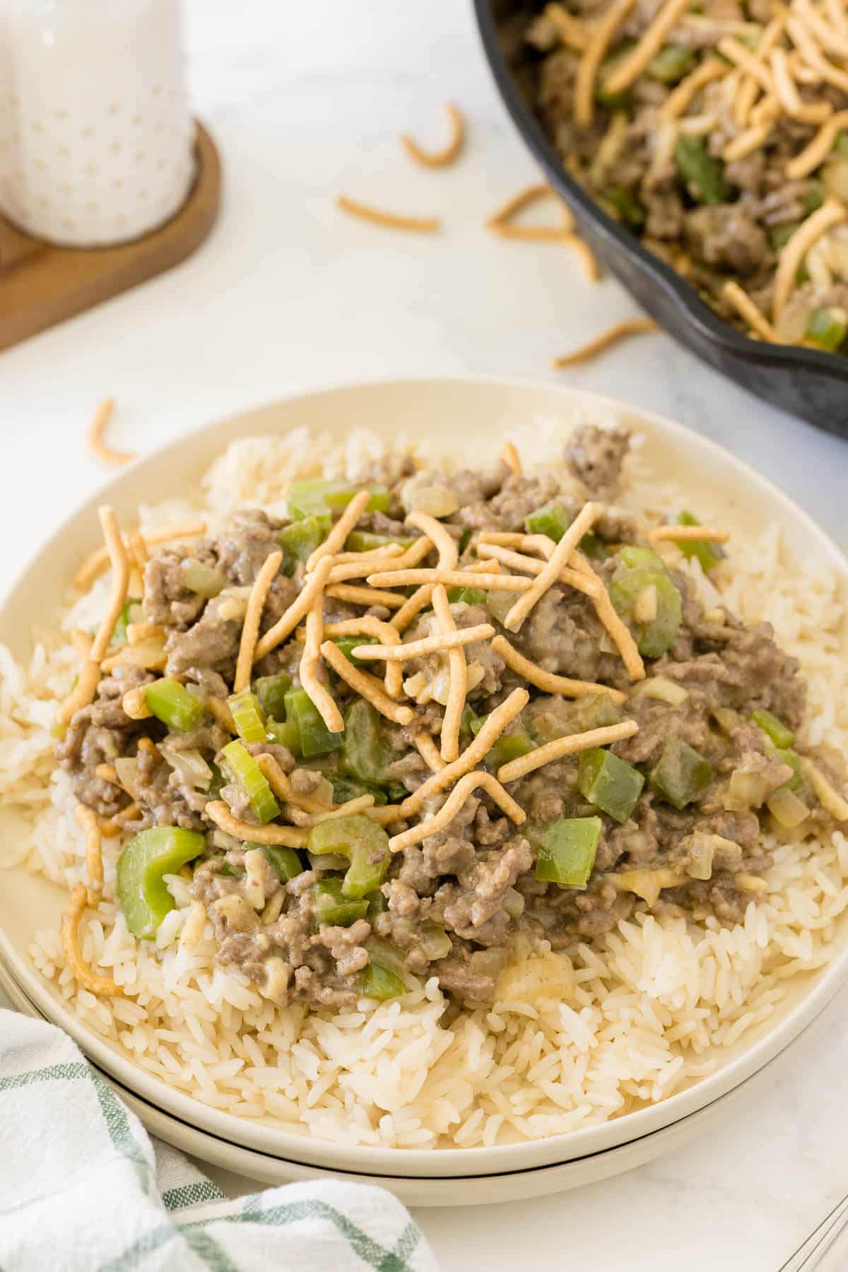 Chow Mein Skillet on a bed of rice on a plate.