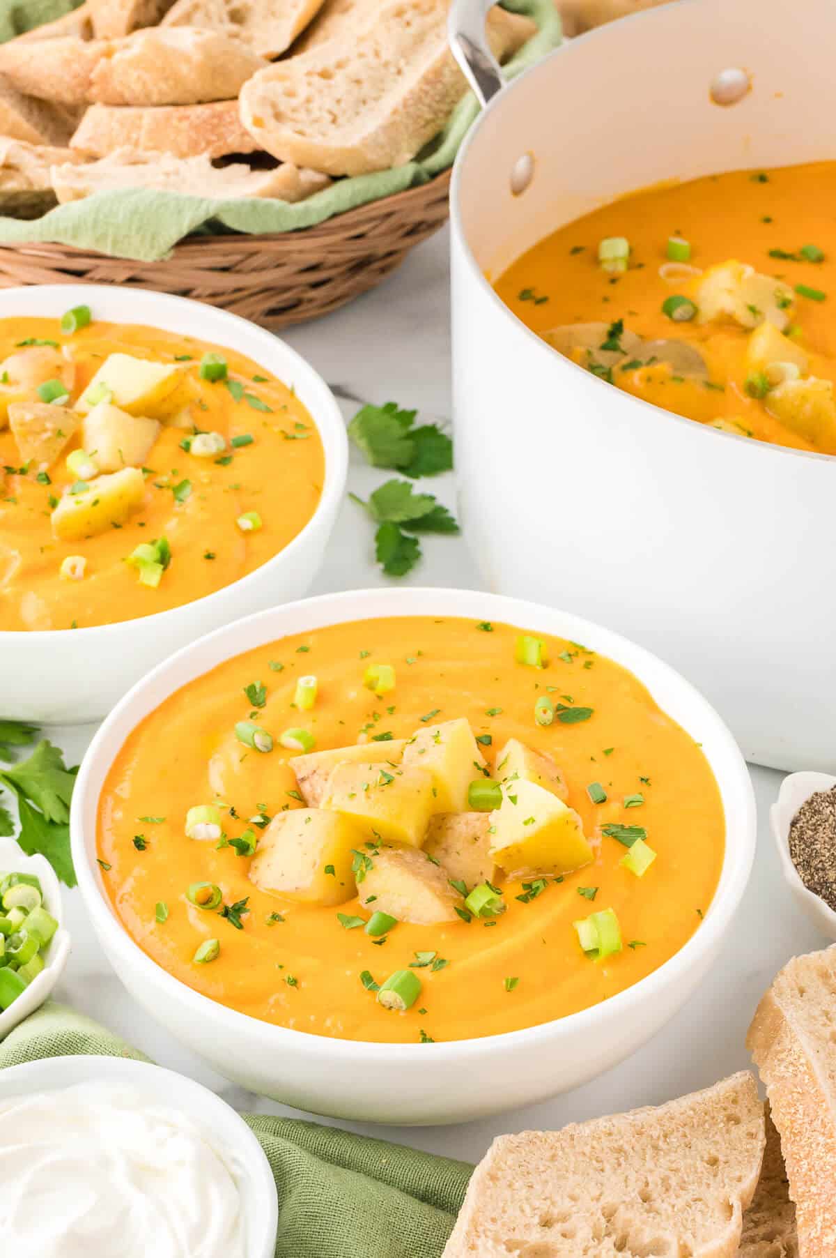 A white bowl of carrot and potato soup.