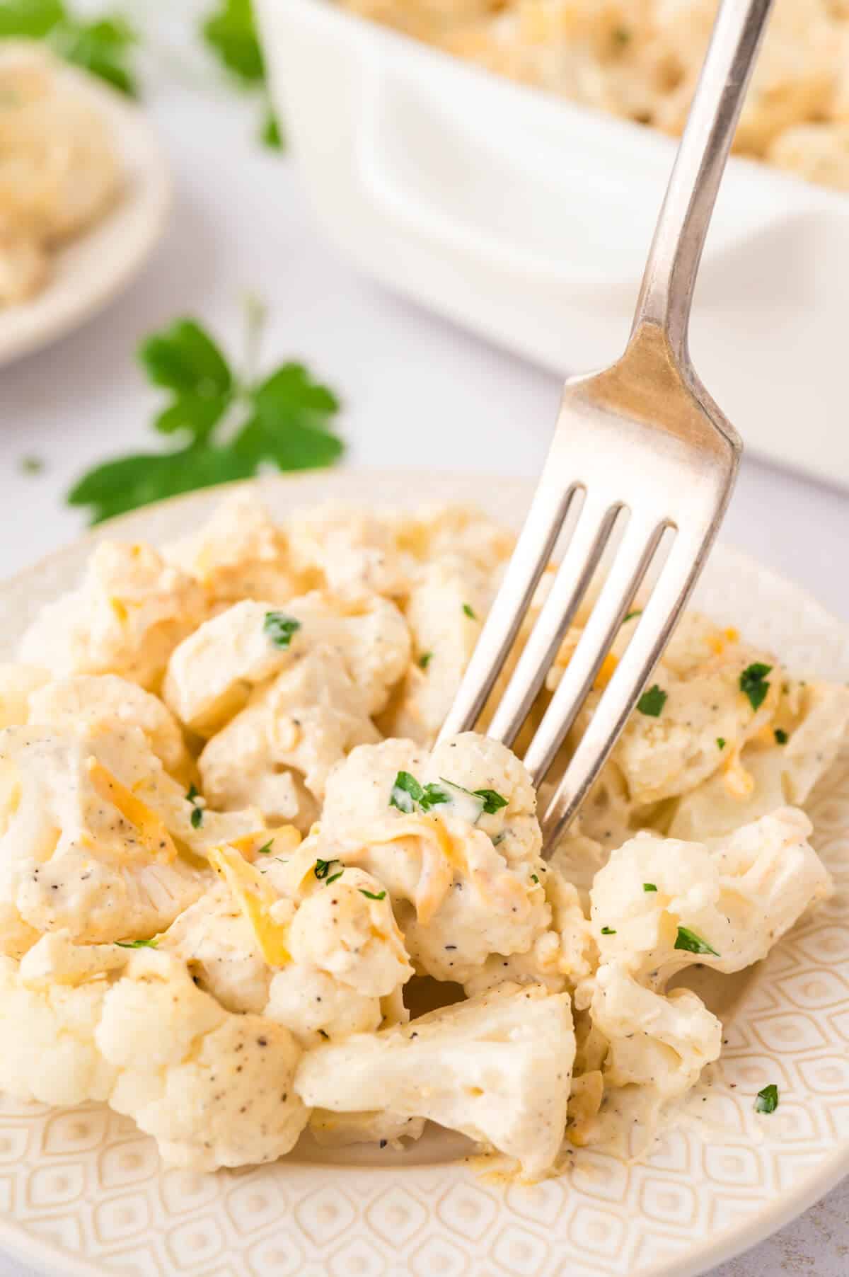 Creamy cauliflower on a plate with a fork.