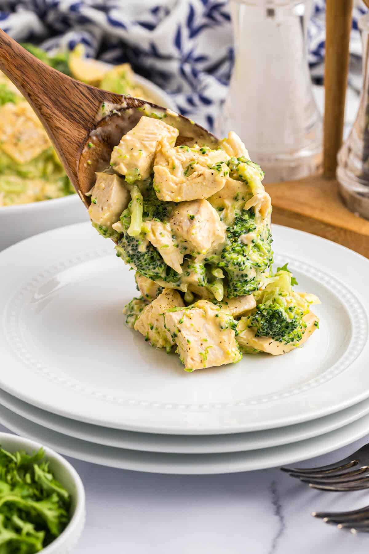 Cheesy chicken and broccoli on a wooden serving spoon.